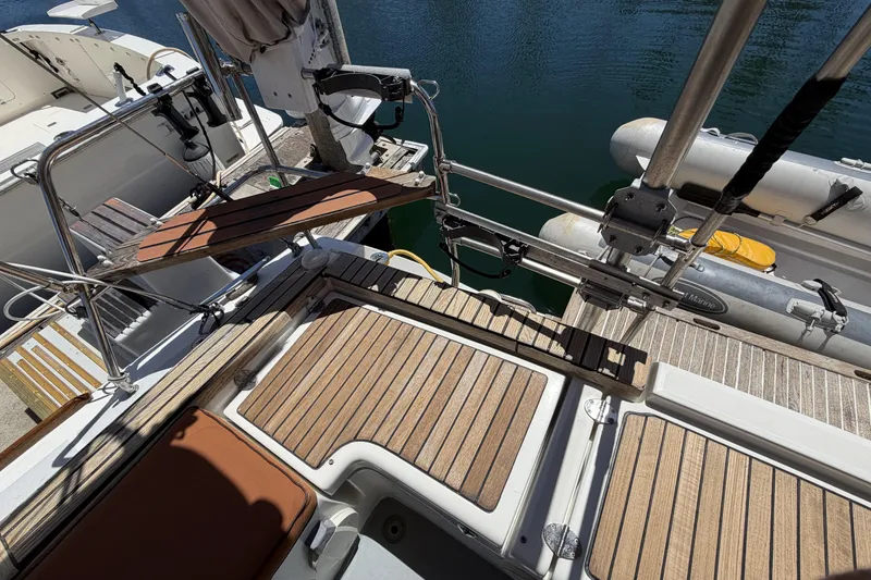 Slide: The Image of Beneteau Oceanis 37 yacht deck, 2010 model, featuring teak flooring and docked inflatable boat. - 25