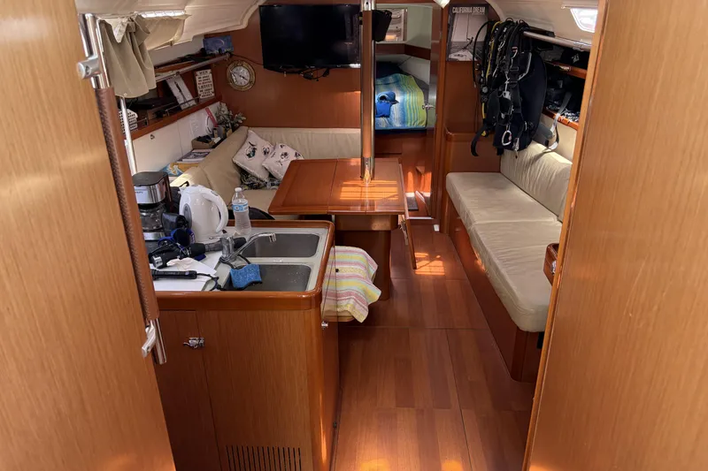 Slide: The Image of Interior of a 2010 Beneteau Oceanis 37 sailboat, featuring cozy seating and a compact kitchen area. - 50