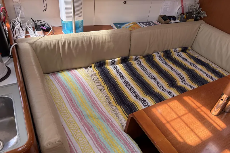 Slide: The Image of Interior of 2010 Beneteau Oceanis 37 yacht with cozy seating and colorful blankets. - 52