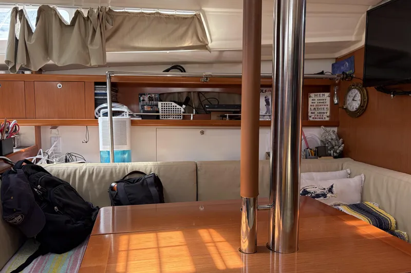 Slide: The Image of Interior of a 2010 Beneteau Oceanis 37 sailboat, featuring cozy seating and wooden finishes. - 53
