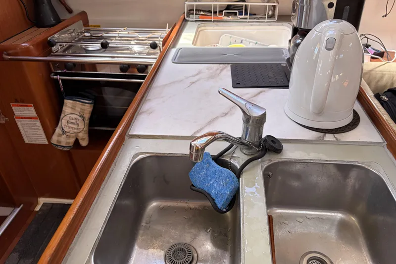 Slide: The Image of Galley kitchen in 2010 Beneteau Oceanis 37 sailboat with sink and kettle. - 61