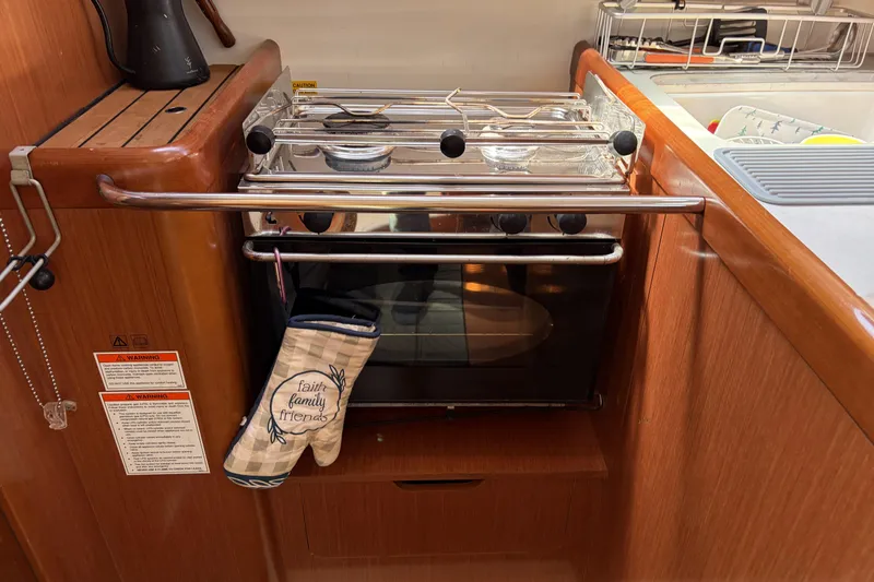 Slide: The Image of Galley kitchen in 2010 Beneteau Oceanis 37 sailboat with oven and mitt. - 63