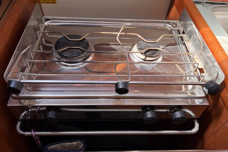 Slide: The Image of Stove in 2010 Beneteau Oceanis 37 yacht kitchen, featuring two burners and metal grates. - 64