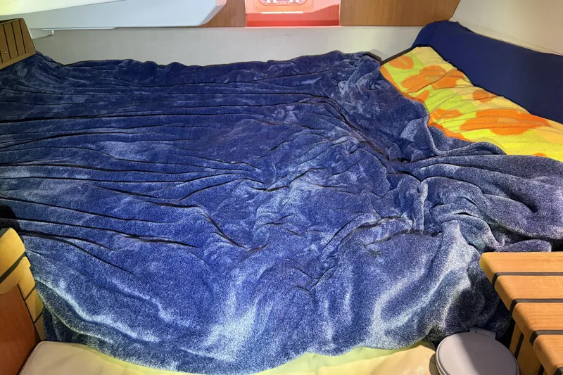Slide: The Image of Cozy cabin bed with blue blanket in 2010 Beneteau Oceanis 37 sailboat. - 66