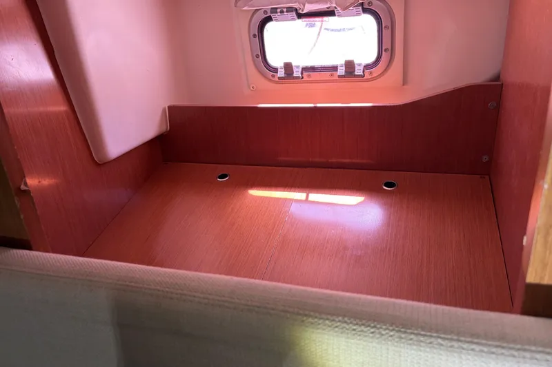 Slide: The Image of Interior cabin space of 2010 Beneteau Oceanis 37 sailboat, featuring wooden finish and porthole. - 67
