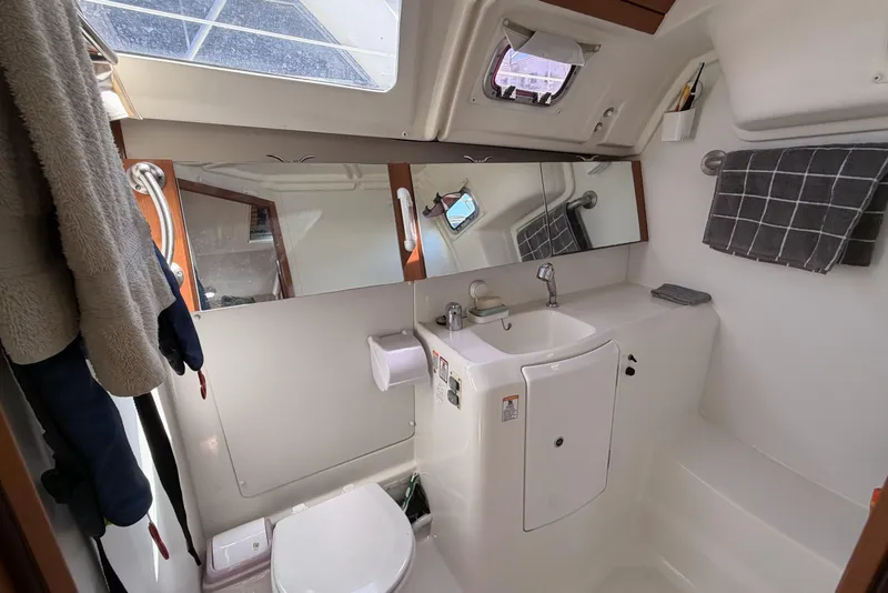 Slide: The Image of Bathroom interior of a 2010 Beneteau Oceanis 37 yacht, featuring a sink, mirror, and toilet. - 73
