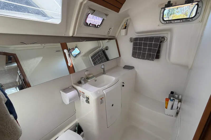 Slide: The Image of Bathroom interior of a 2010 Beneteau Oceanis 37 yacht, featuring sink, mirror, and toiletries. - 74