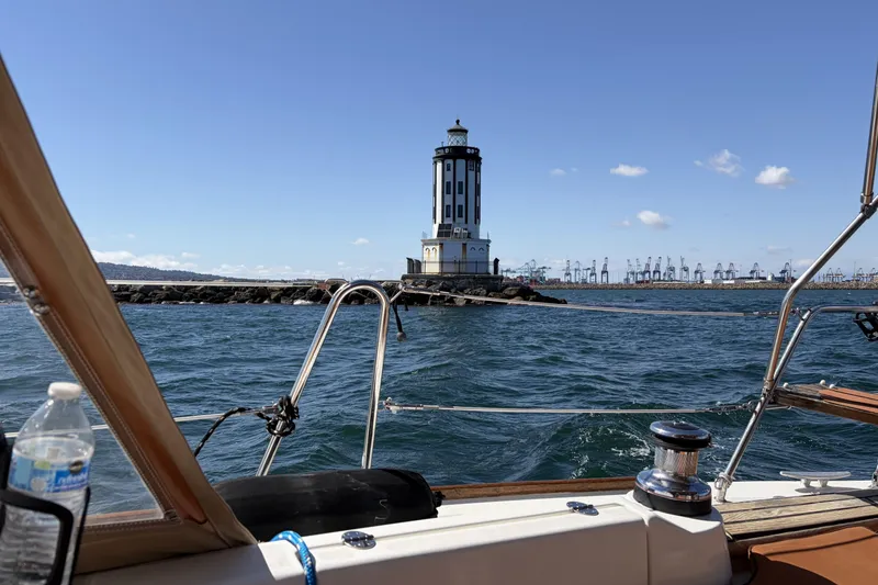 Slide: The Image of Beneteau Oceanis 37 sailing near a lighthouse with cranes in the background, 2010 model. - 75