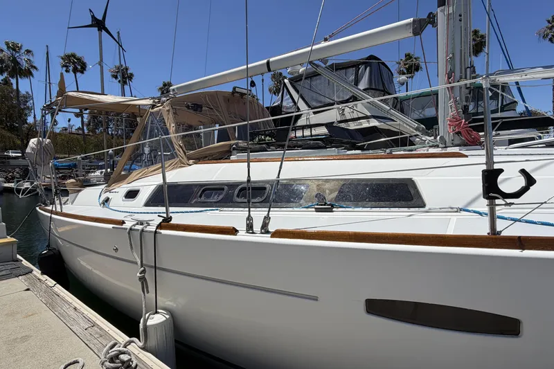Slide: The Image of 2010 Beneteau Oceanis 37 sailboat docked at marina, sunny day, palm trees in background. - 8