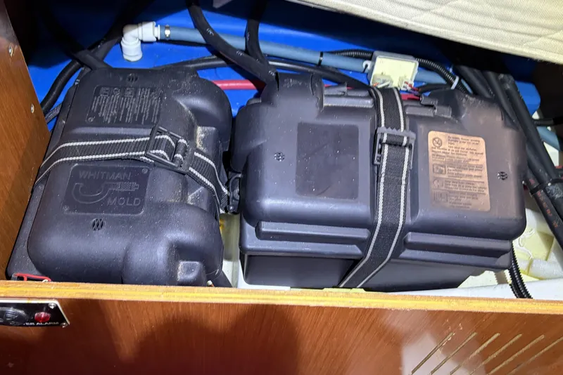 Slide: The Image of Battery compartment of a 2010 Beneteau Oceanis 37 sailboat, featuring secured battery boxes. - 80