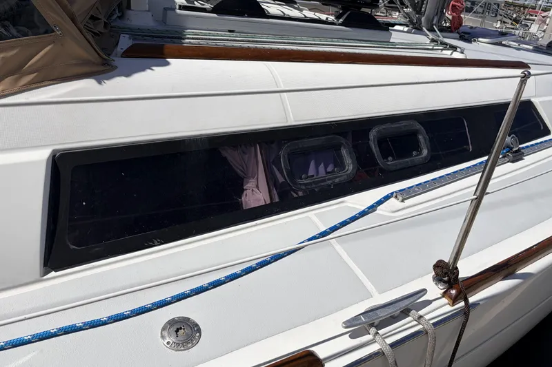 Slide: The Image of 2010 Beneteau Oceanis 37 sailboat deck with windows and blue rope detail. - 9