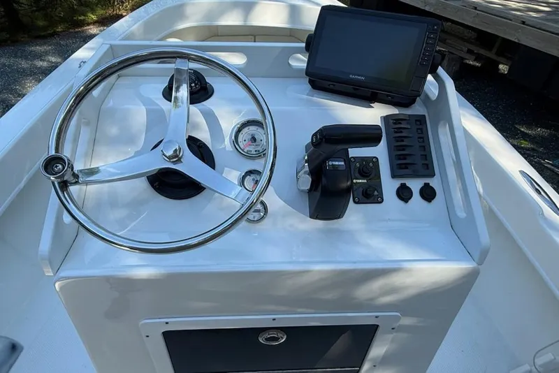 Slide: The Image of 2023 Seaway 18 Sportsman boat dashboard with steering wheel and navigation controls. - 2