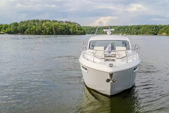 Slide: The Image of 2023 Cruisers Yachts 42 Cantius on serene lake with lush forest backdrop. - 2