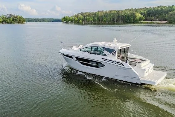 Slide: The Image of 2023 Cruisers Yachts 42 Cantius cruising on a serene lake with lush forest backdrop. - 22