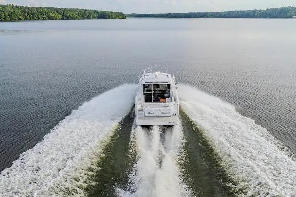 Slide: The Image of 2023 Cruisers Yachts 42 Cantius cruising on a serene lake, leaving a wake trail. - 25