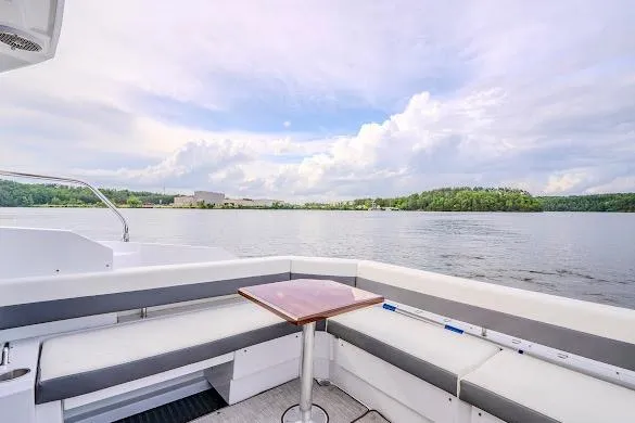 Slide: The Image of 2023 Cruisers Yachts 42 Cantius deck with seating, overlooking serene lake and cloudy sky. - 28