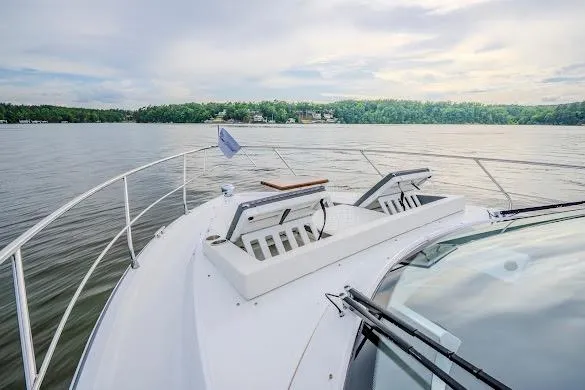 Slide: The Image of 2023 Cruisers Yachts 42 Cantius on serene lake with lush shoreline. - 34