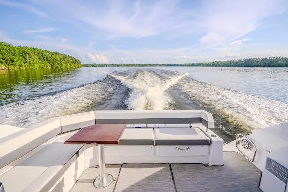 Slide: The Image of 2023 Cruisers Yachts 42 Cantius cruising on a serene lake with lush green shoreline. - 37