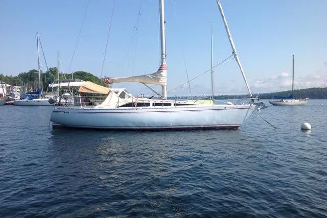 The Image of 1981 Yamaha 36 sailboat anchored on calm water under clear blue sky. - 0