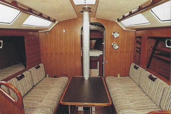 Slide: The Image of Interior of a 1981 Yamaha 36 sailboat with wood paneling and striped seating. - 1
