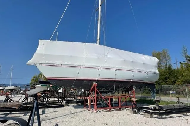 Slide: The Image of 1981 Yamaha 36 sailboat on stands, covered in white tarp, outdoors. - 6