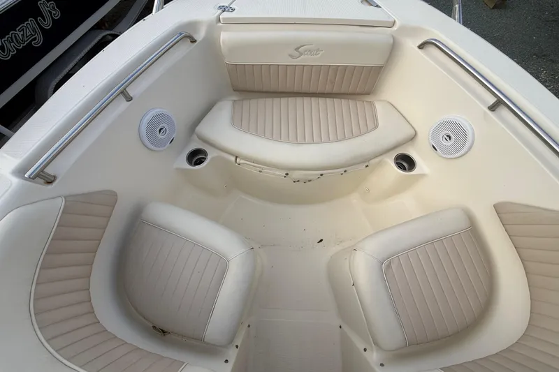 Slide: The Image of Interior seating of a 2005 Scout 222 Dorado boat with beige upholstery and speakers. - 4