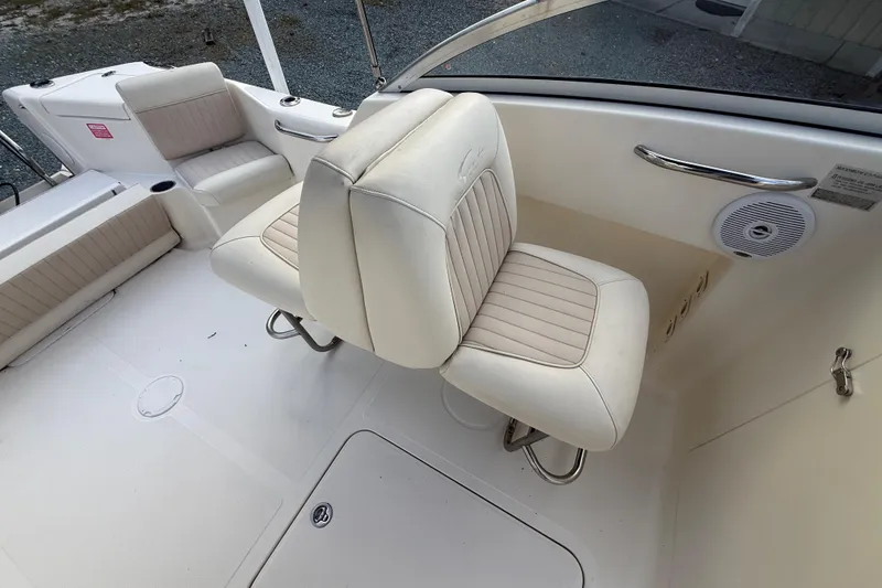 Slide: The Image of 2005 Scout 222 Dorado boat interior with white cushioned seating and speaker. - 5