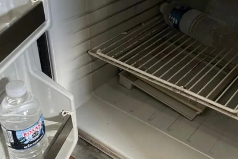 Slide: The Image of Open fridge in 2017 Robalo R265 Walkaround boat with water bottles inside. - 34