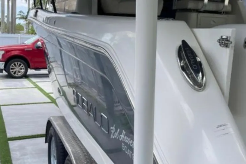 Slide: The Image of 2017 Robalo R265 Walkaround boat parked beside a red vehicle. - 20