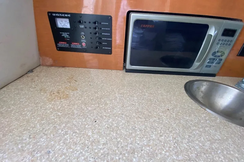 Slide: The Image of 2017 Robalo R265 Walkaround interior with microwave, sink, and control panel. - 8