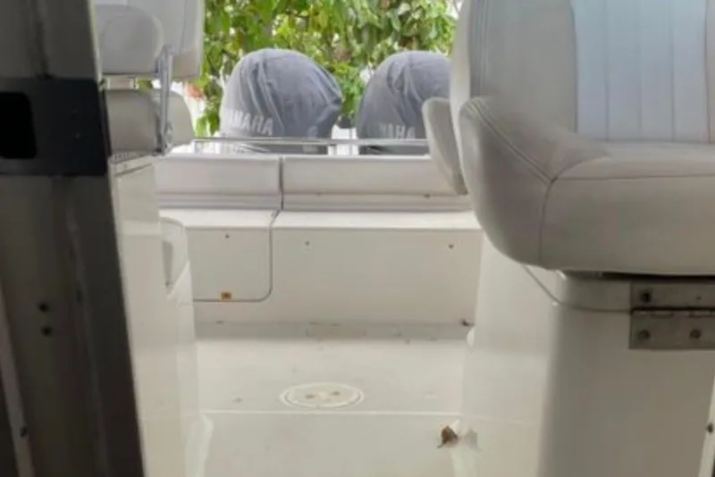 Slide: The Image of Interior view of 2017 Robalo R265 Walkaround boat with white seating and covered engines. - 35