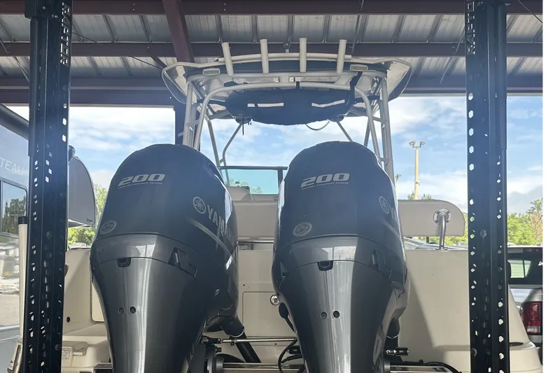 Slide: The Image of 2017 Robalo R265 Walkaround with twin Yamaha 200 engines under a metal roof. - 4