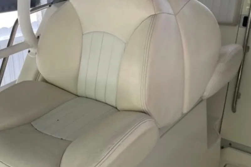 Slide: The Image of Captain's seat on a 2017 Robalo R265 Walkaround boat, featuring white upholstery. - 23