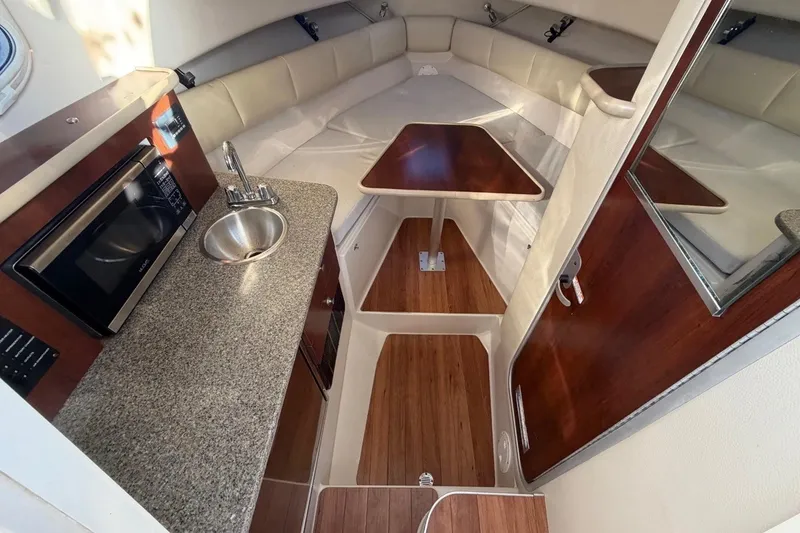 Slide: The Image of Interior of 2017 Robalo R265 Walkaround boat with kitchenette and seating area. - 6
