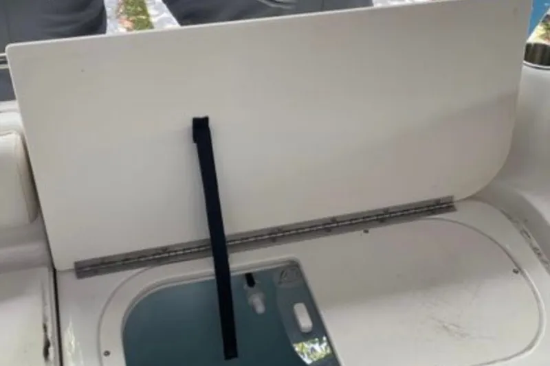 Slide: The Image of 2017 Robalo R265 Walkaround boat interior with open hatch and storage compartment. - 26
