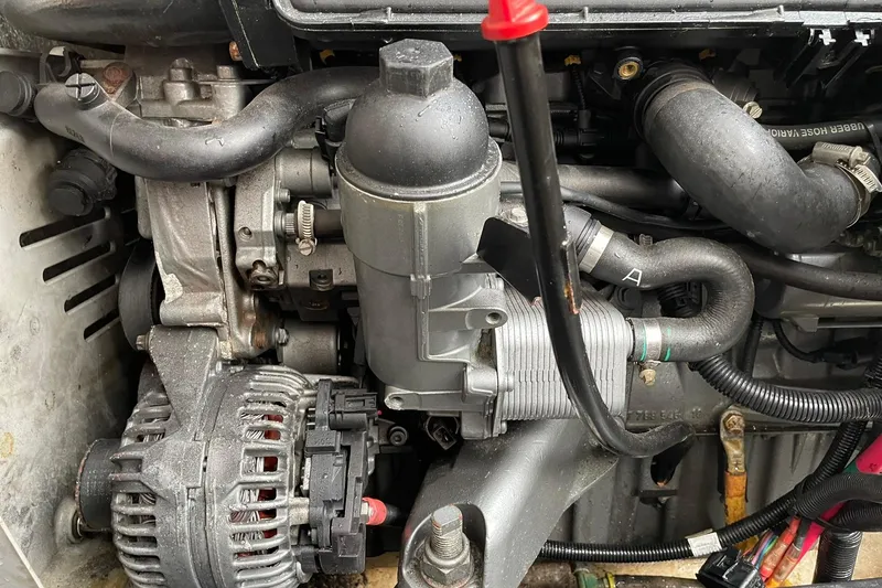 Slide: The Image of Engine compartment of a 2008 Luhrs 28 Open boat, showcasing mechanical components and hoses. - 11