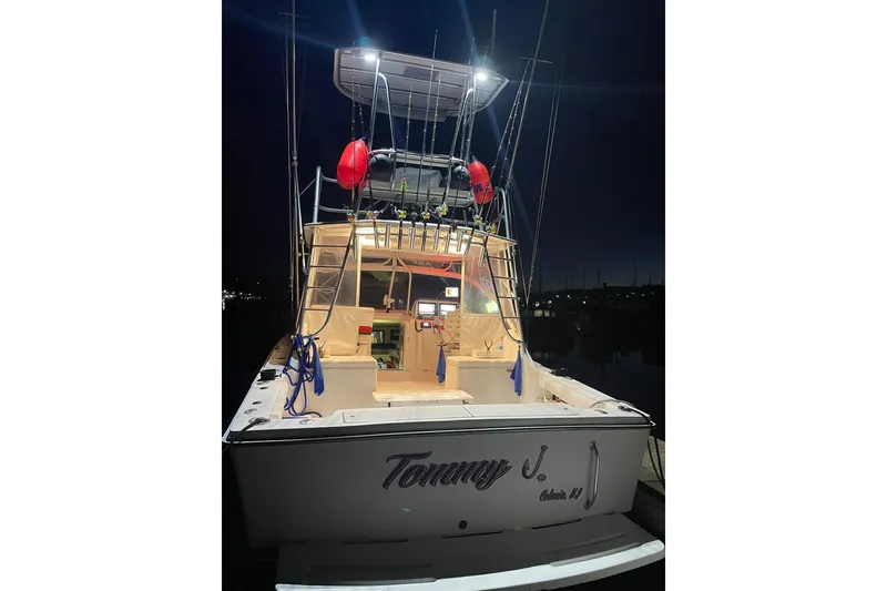 Slide: The Image of 2008 Luhrs 28 Open boat at night, illuminated deck, fishing rods visible. - 18