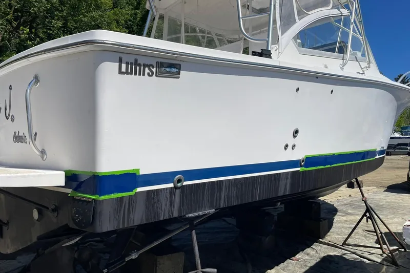 Slide: The Image of 2008 Luhrs 28 Open boat on dry dock, undergoing maintenance with visible tape and supports. - 26