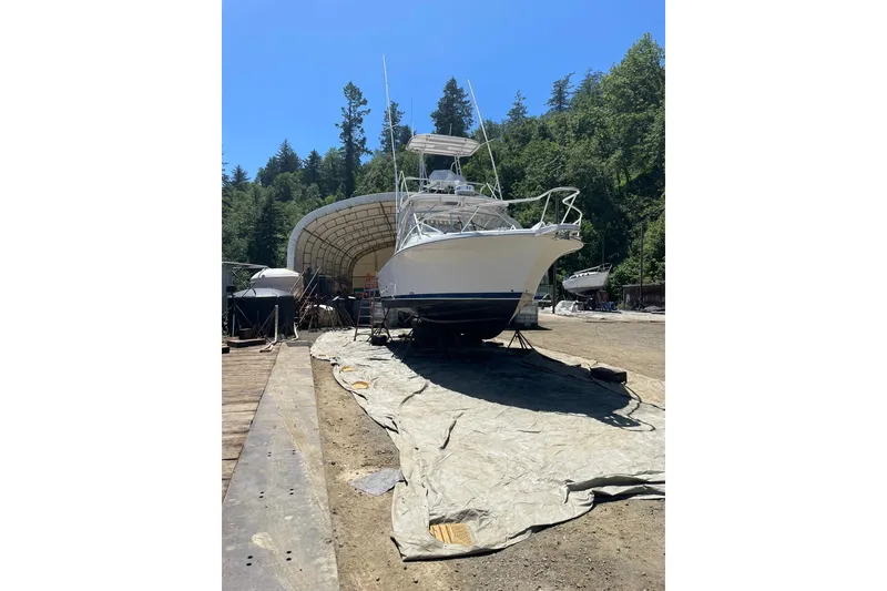 Slide: The Image of 2008 Luhrs 28 Open boat on land, surrounded by trees and clear blue sky. - 29