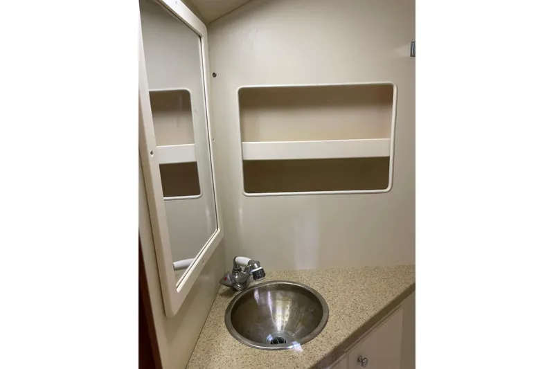 Slide: The Image of 2008 Luhrs 28 Open boat bathroom with sink, mirror, and storage shelf. - 3