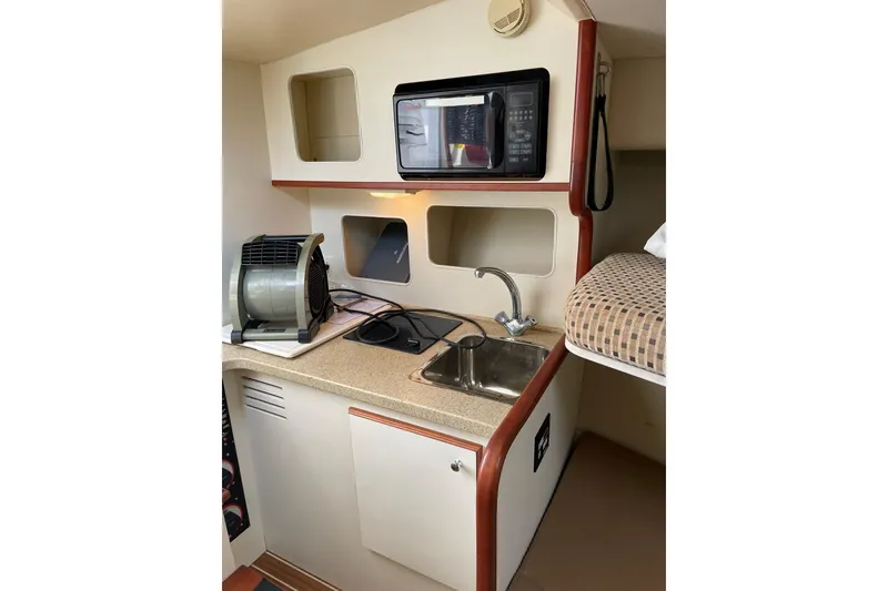 Slide: The Image of Compact galley kitchen in 2008 Luhrs 28 Open boat with sink, microwave, and storage. - 6