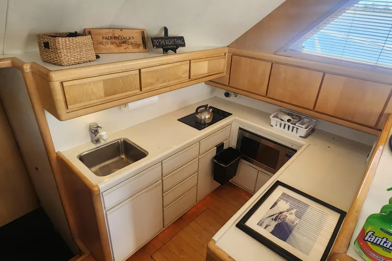 Slide: The Image of 1995 Bertram 43 Convertible yacht kitchen with wooden cabinets and modern appliances. - 12