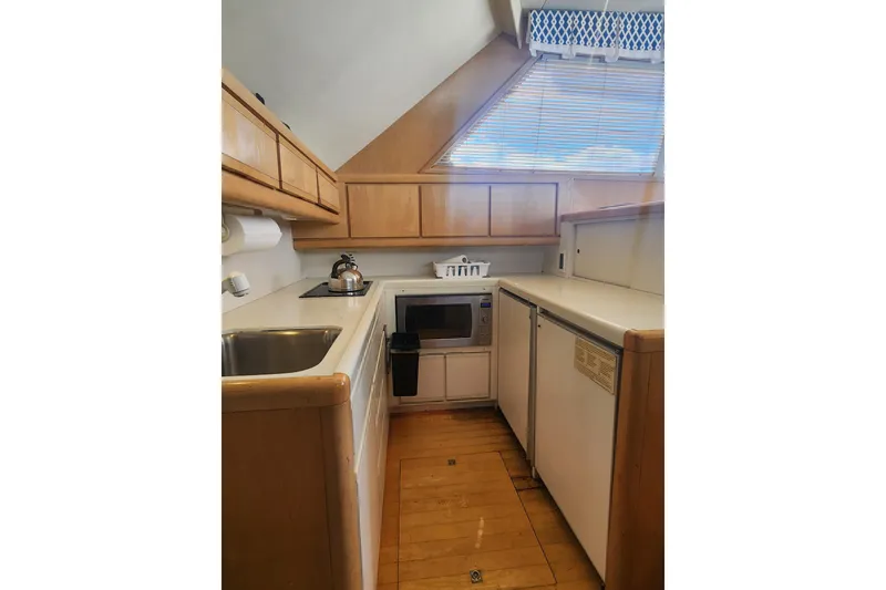 Slide: The Image of Compact kitchen in a 1995 Bertram 43 Convertible yacht with modern appliances. - 13