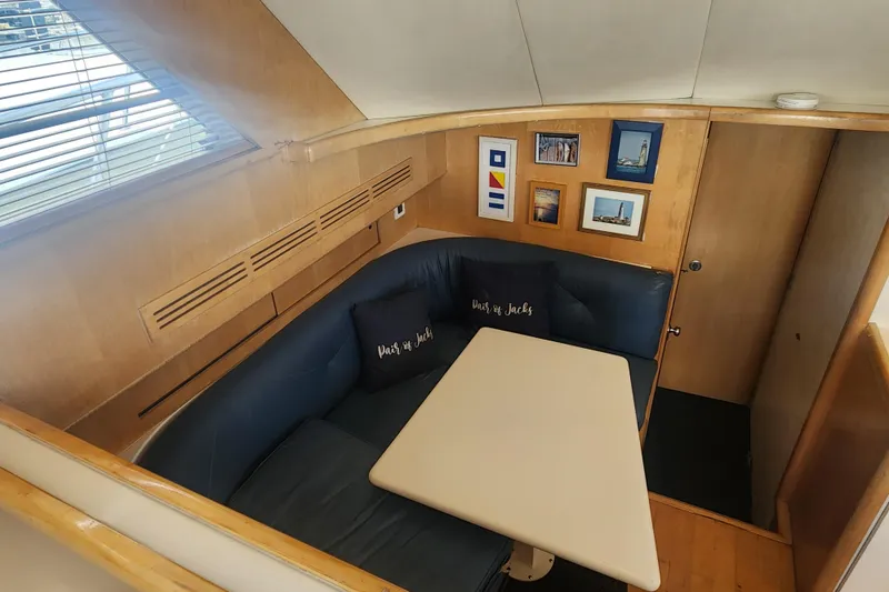 Slide: The Image of Interior of 1995 Bertram 43 Convertible yacht with cozy seating and framed artwork. - 14