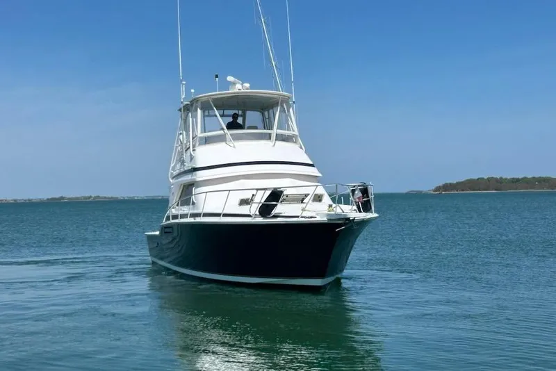 Slide: The Image of 1995 Bertram 43 Convertible yacht cruising on calm blue waters. - 2