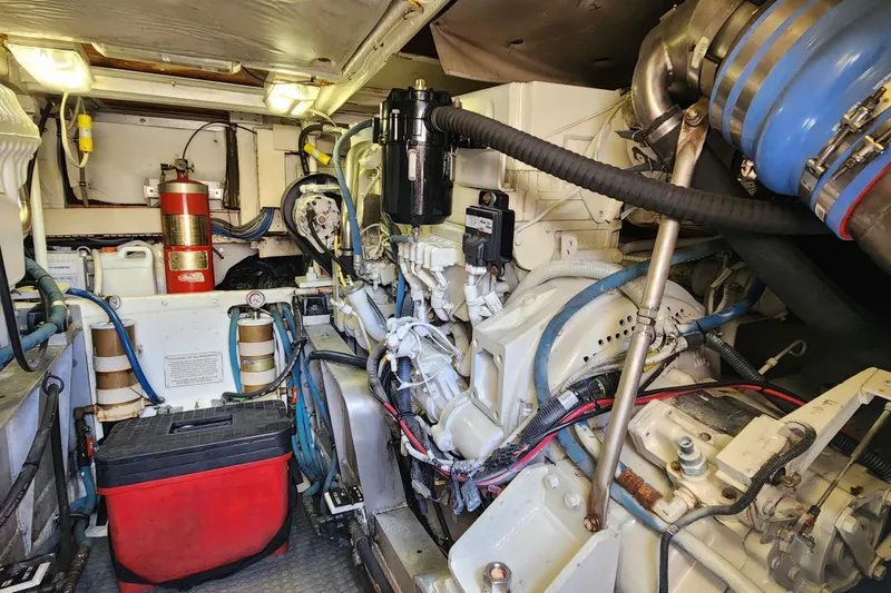 Slide: The Image of Engine room of a 1995 Bertram 43 Convertible yacht, featuring mechanical components and fire extinguisher. - 20