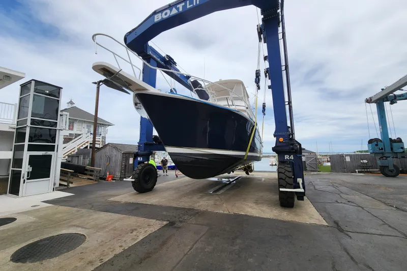 Slide: The Image of 1995 Bertram 43 Convertible yacht lifted by boat hoist at marina. - 3