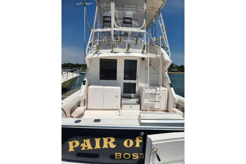 Slide: The Image of 1995 Bertram 43 Convertible yacht docked, rear view with ladder and seating area. - 4