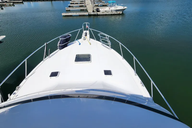 Slide: The Image of Bow view of a 1995 Bertram 43 Convertible yacht docked in a marina. - 5