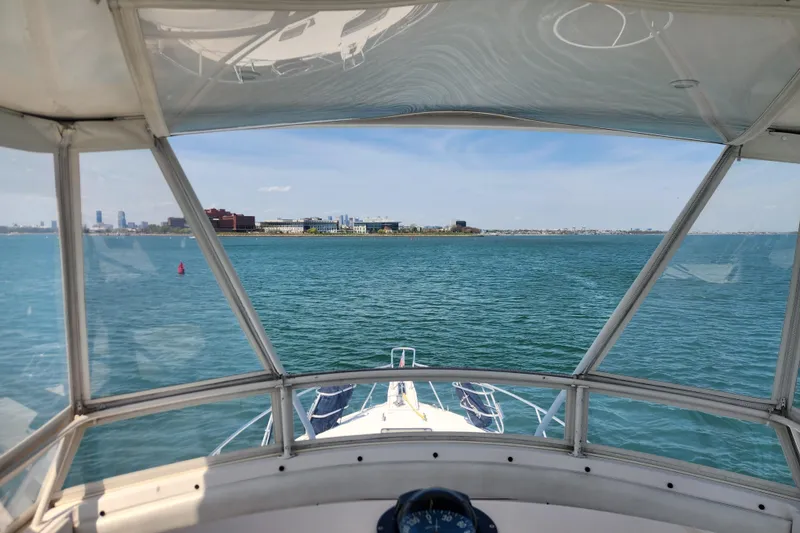 Slide: The Image of View from 1995 Bertram 43 Convertible boat, overlooking calm blue waters and distant shoreline. - 6